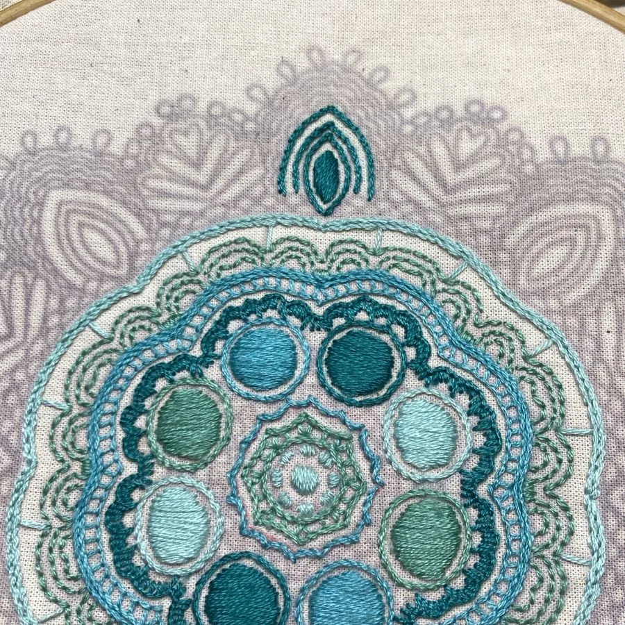 Mandala bordado en hilo turquesa y verde por una alumna de MAKI