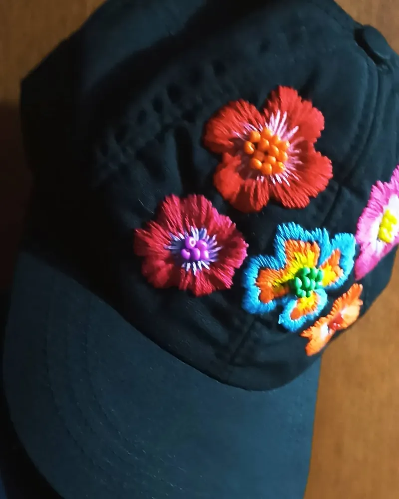 Gorra negra con flores bordadas en hilo de colores