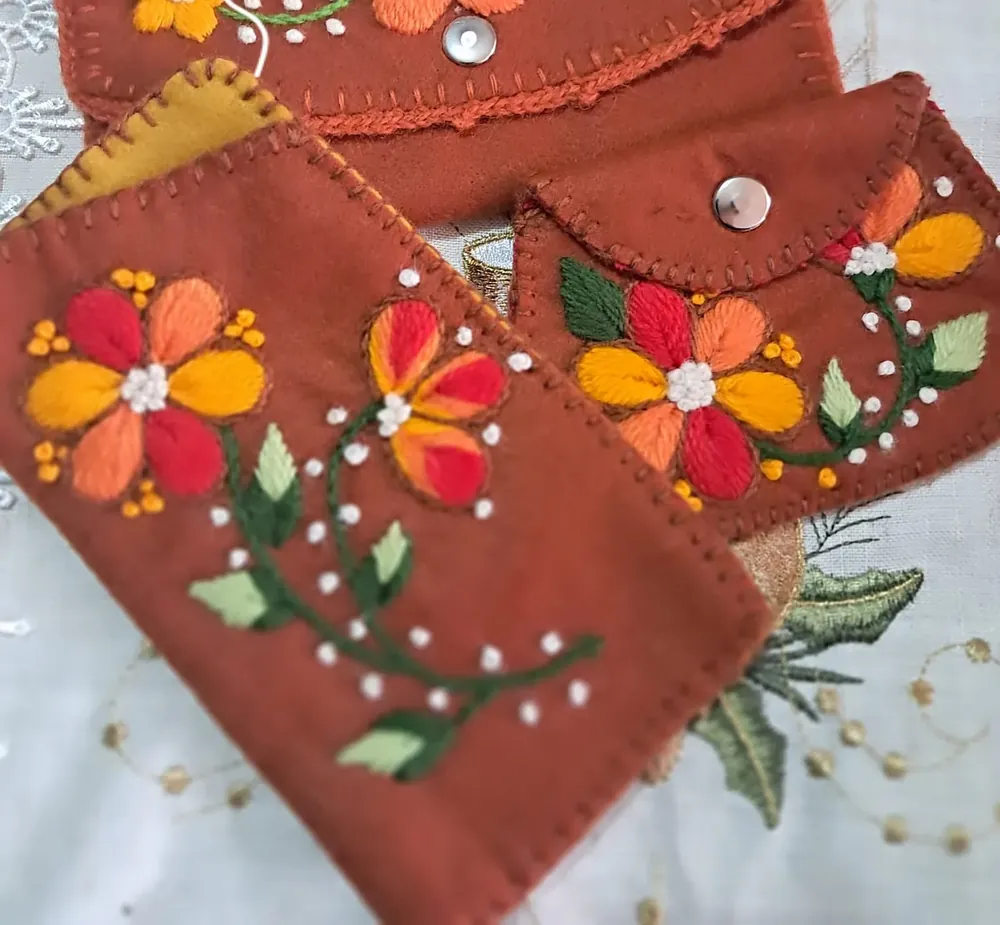 Monederos de tela terracota con flores naranjas bordadas